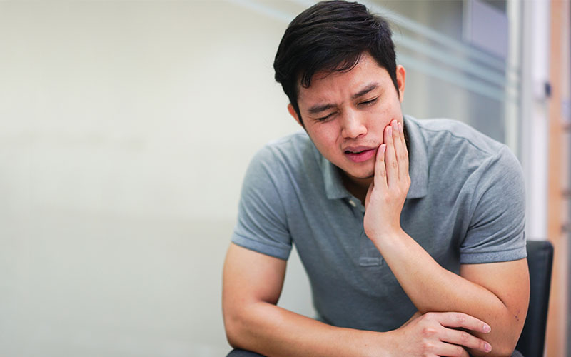 Griesbach Dental - Male patient holding their jaw and experiencing a dental emergency